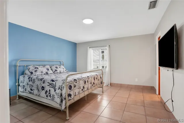 a bedroom with a bed and a flat screen tv