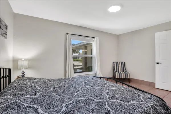 a bedroom with two beds and windows