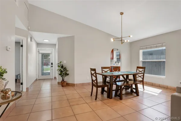 a view of a dining room with furniture and a chandelier