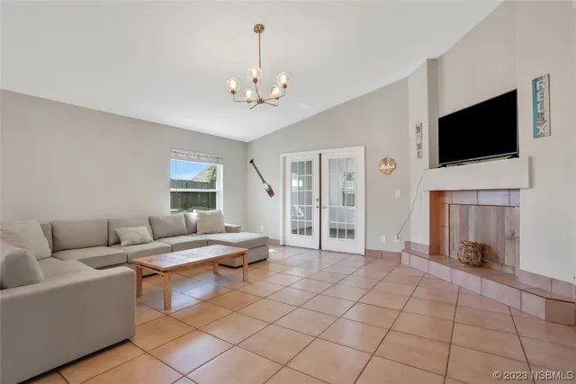 a view of an empty room with wooden floor and windows