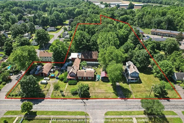 an aerial view of residential house with outdoor space and trees all around