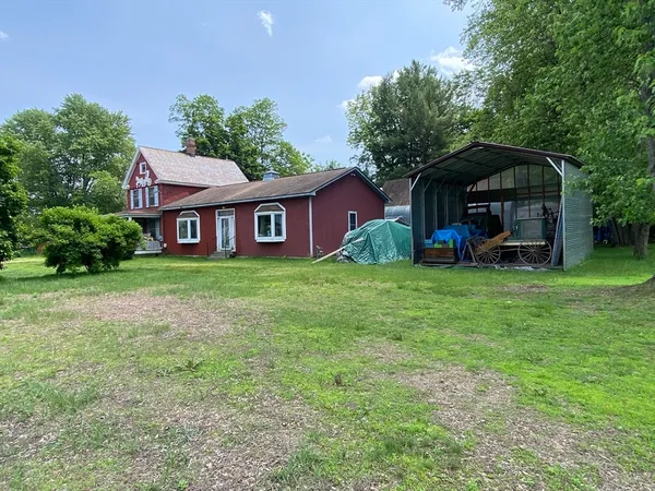 a view of a house with a yard and sitting area