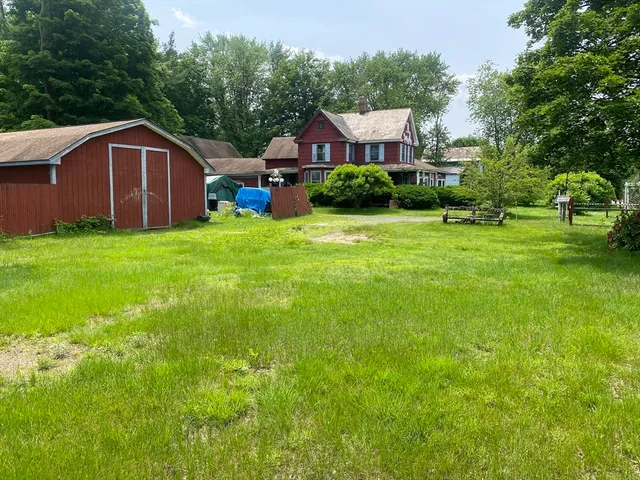 a view of house with a yard and sitting area