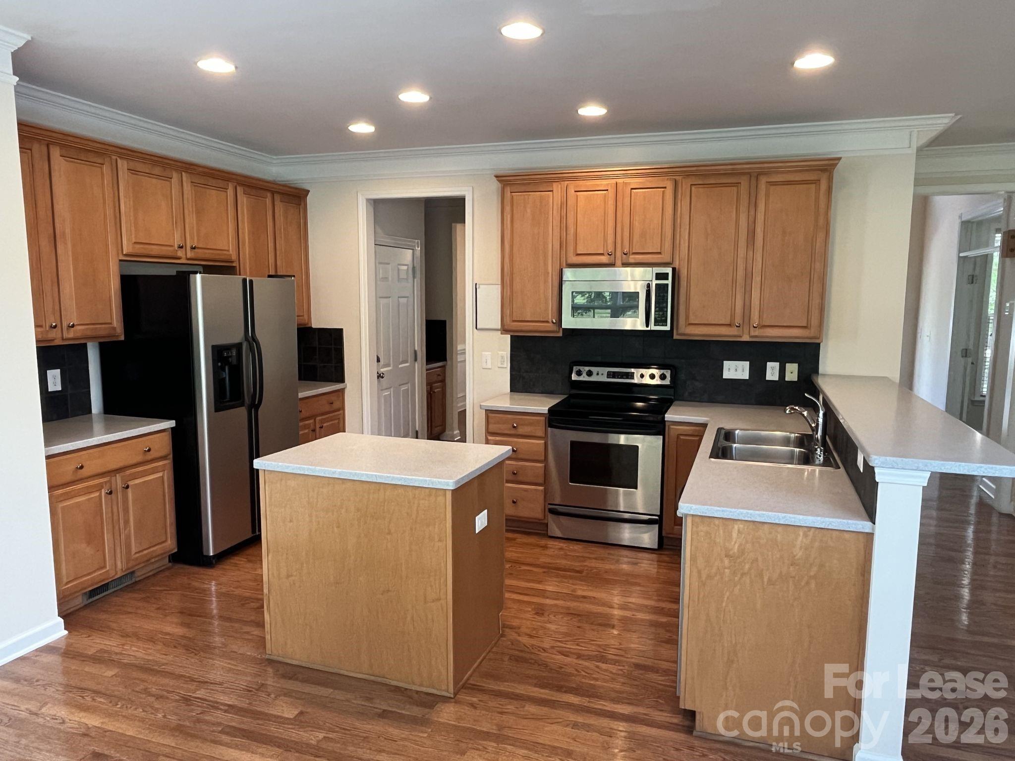 8531 Camberly Road Huntersville, NC 28078 - Photo 9 of 32 a kitchen with stainless steel appliances granite countertop a refrigerator stove and oven