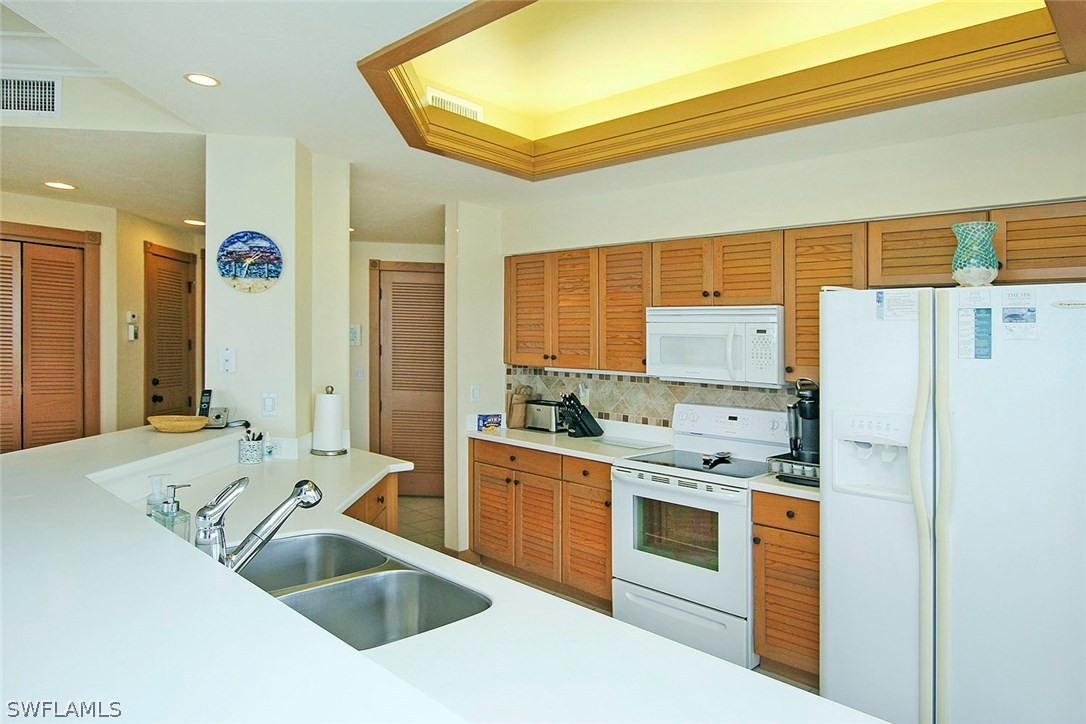 1251 South Seas Plantation Road Captiva, FL 33924 - Photo 6 of 24 a kitchen with stainless steel appliances granite countertop a sink stove and refrigerator