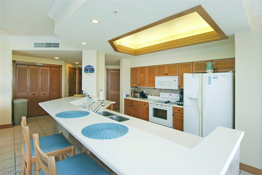 1251 South Seas Plantation Road Captiva, FL 33924 - Photo 7 of 24 a kitchen with stainless steel appliances granite countertop a sink and a refrigerator