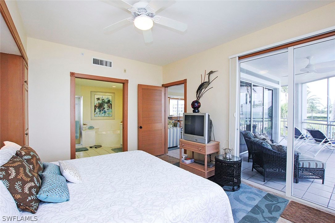 1251 South Seas Plantation Road Captiva, FL 33924 - Photo 9 of 24 a bedroom with a bed wooden floor and large window