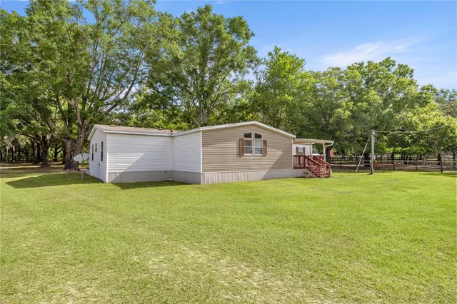a backyard of a house with lots of green space and fountain