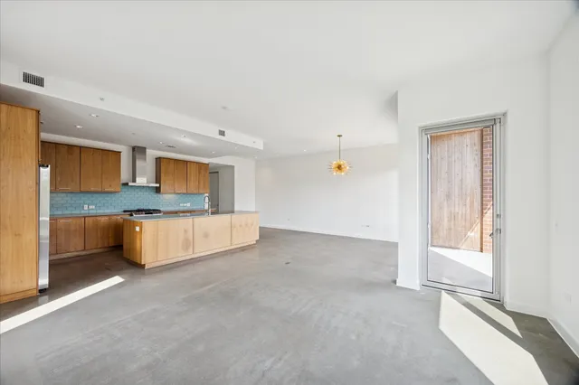 a large white kitchen with a sink and a large window