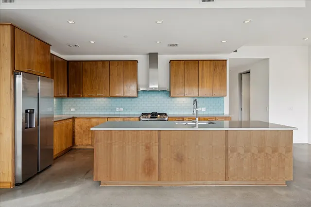 a kitchen with stainless steel appliances granite countertop a sink a stove and a refrigerator