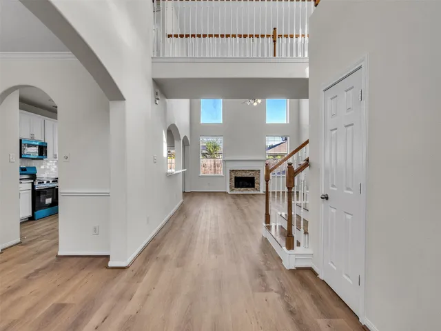 a view of a hallway with wooden floor and staircase