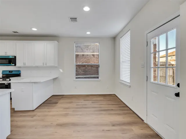 a view of a kitchen with wooden floor and electronic appliances