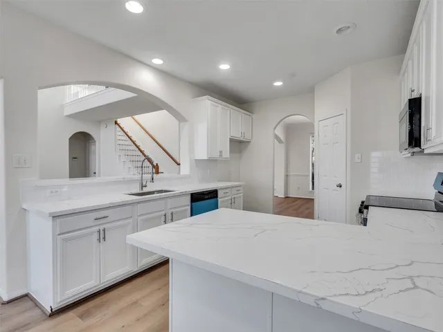 a large white kitchen with stainless steel appliances