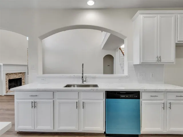 a kitchen with granite countertop white cabinets and white appliances