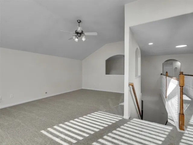 a view of a room with wooden floor and ceiling fan