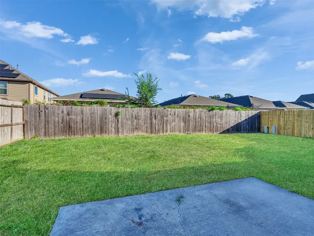 a view of a backyard with wooden fence