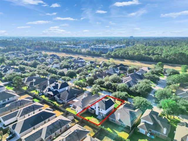 an aerial view of residential houses with outdoor space and trees