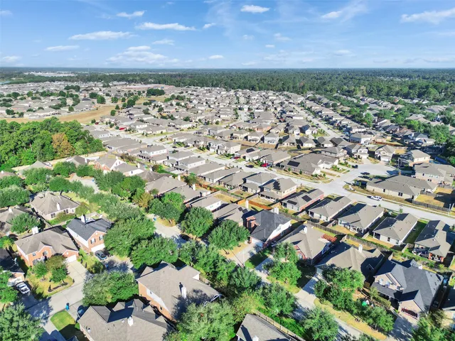an aerial view of residential houses with outdoor space and trees