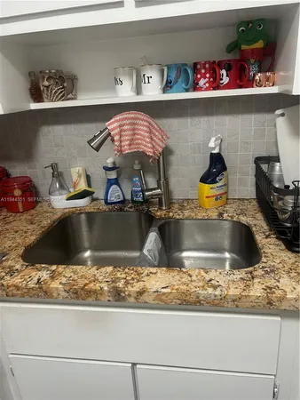 a kitchen with a sink a counter and cabinets