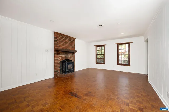 an empty room with fireplace and windows