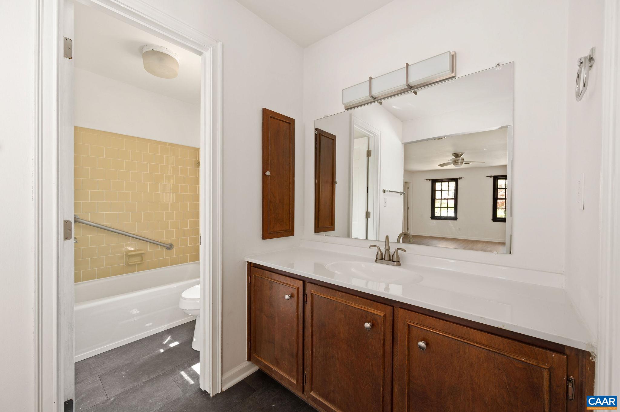 104 Smithfield Court, Unit A Charlottesville, VA 22901 - Photo 16 of 25 a bathroom with a granite countertop sink mirror and vanity