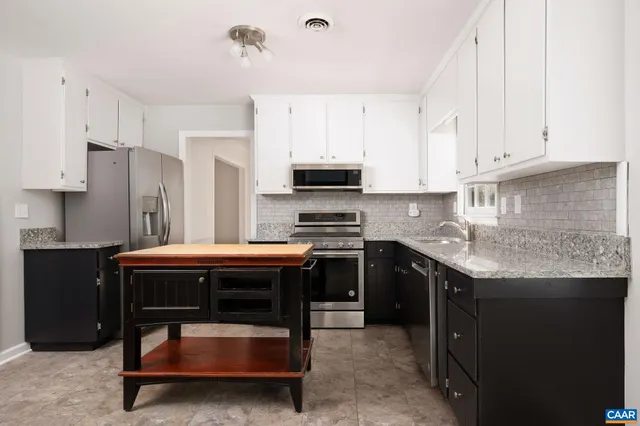 a kitchen with stainless steel appliances granite countertop a stove refrigerator sink and cabinets