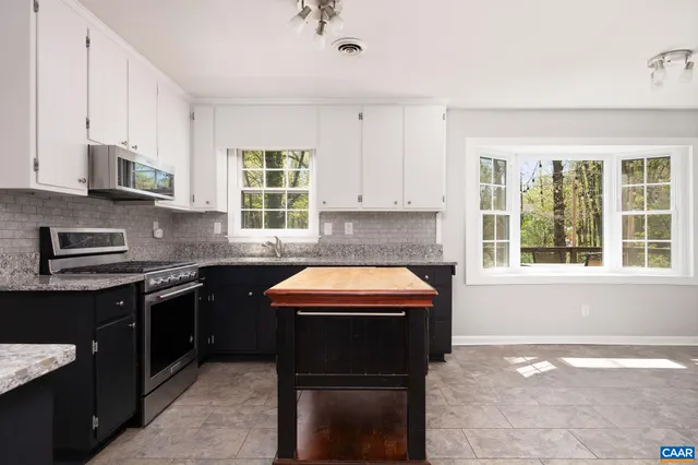 a kitchen with stainless steel appliances granite countertop a stove sink and cabinets