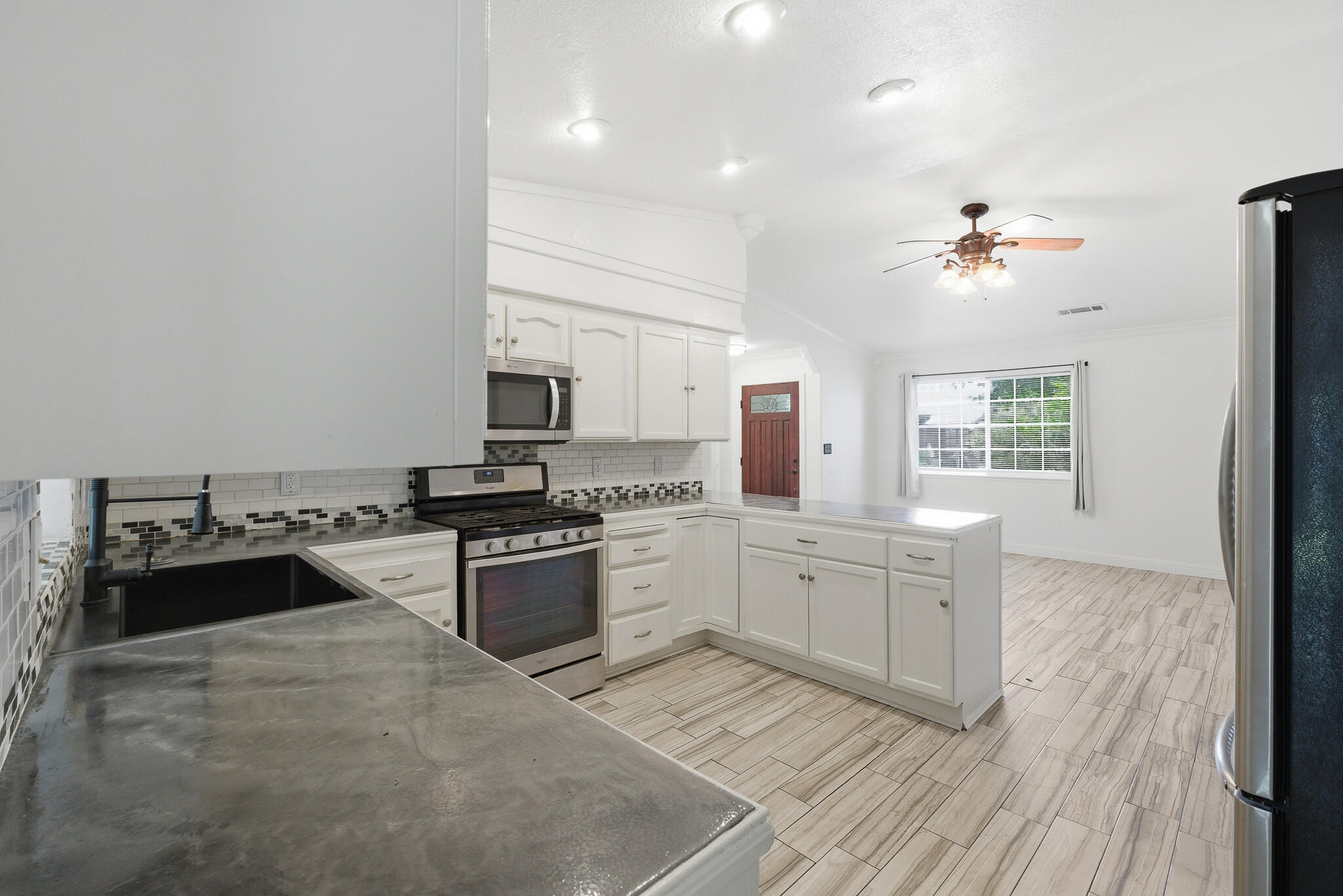 618 Birdsong Court Exeter, CA 93221 - Photo 13 of 62 a large kitchen with granite countertop a stove top oven a sink a dining table and chairs
