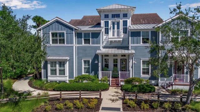 a view of a brick house with a yard and plants