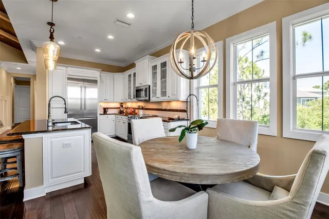 a view of a swimming pool with a table and chairs under palm trees
