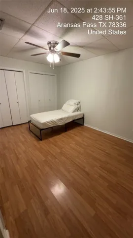 an empty room with wooden floor and fan