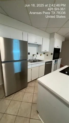 a kitchen with stainless steel appliances a refrigerator sink and cabinets