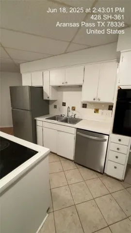 a kitchen with stainless steel appliances a refrigerator sink and cabinets