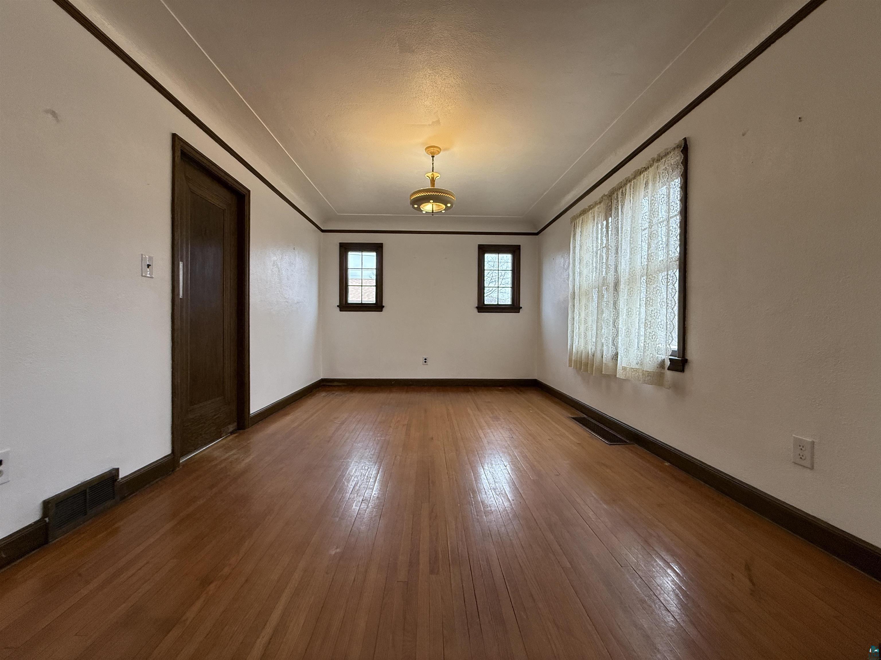 3001 3rd Avenue West Hibbing, MN 55746 - Photo 11 of 38 Spare room featuring baseboards and dark wood-style flooring