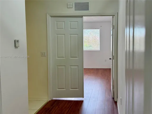 a view of a hallway with wooden floor