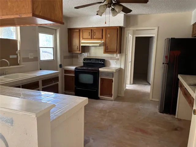 a kitchen with stainless steel appliances kitchen island a stove a sink and a refrigerator