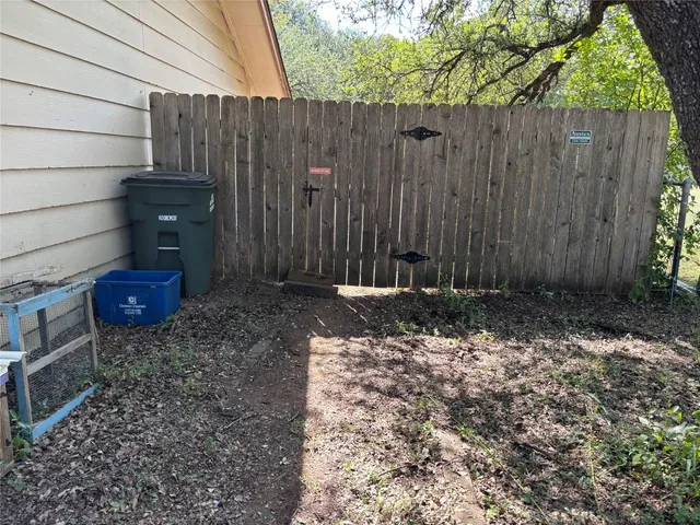a view of a backyard with wooden fence