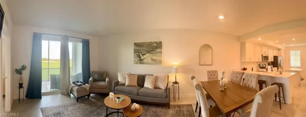 a living room with furniture a large window and a chandelier