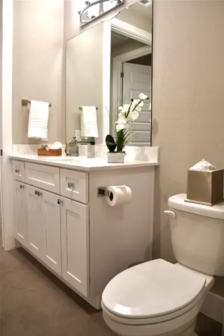 a kitchen with stainless steel appliances kitchen island granite countertop a refrigerator a stove a sink dishwasher and white cabinets with wooden floor