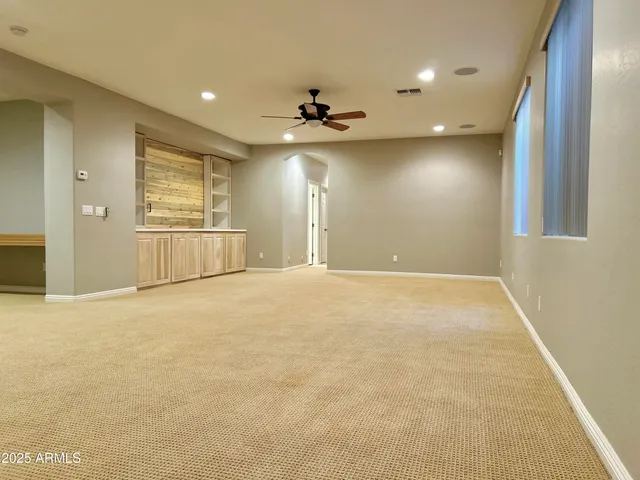 an empty room with ceiling fan and window