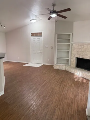 a view of empty room with wooden floor and fireplace