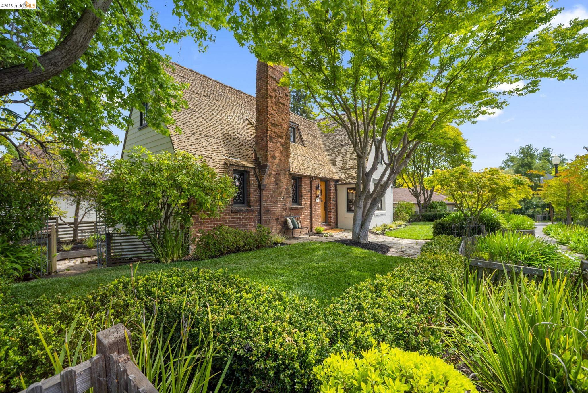 1087 Hubert Road Oakland, CA 94610 - Photo 59 of 67 Dormered home with a brick and stucco exterior, featuring a shingle roof and a prominent brick chimney