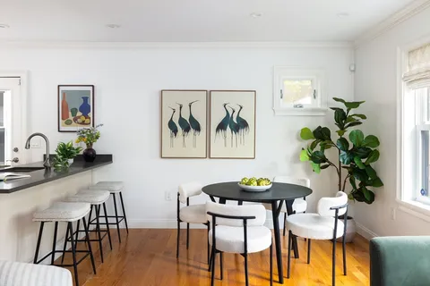 a view of a dining room with furniture and a potted plant