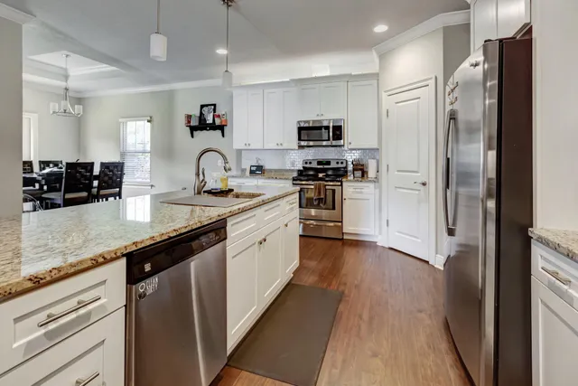 a kitchen with granite countertop a refrigerator stove top oven and sink