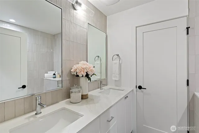 a bathroom with a sink and mirror with shower