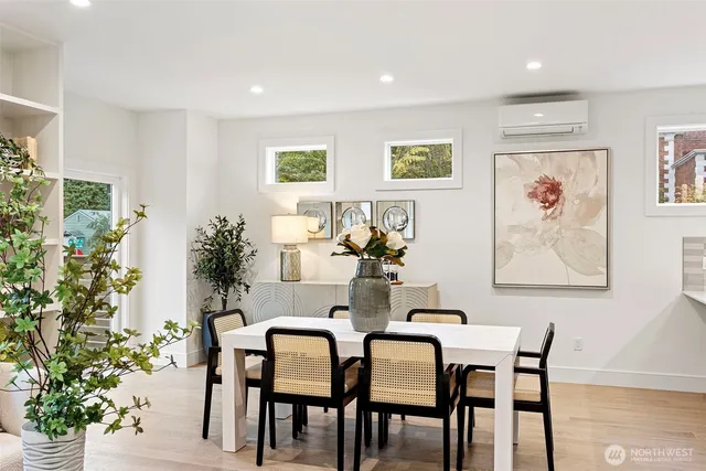 a view of a dining room and livingroom with furniture wooden floor and a potted plant