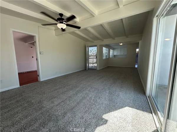 a view of a livingroom with a ceiling fan and window