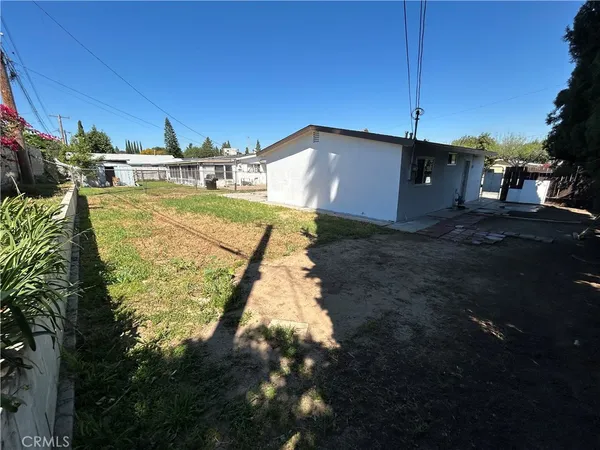 a backyard of a house with table and chairs
