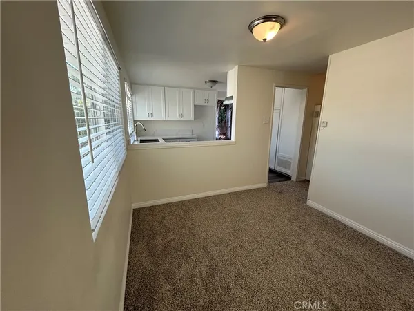 a view of hallway with wooden floor and a window