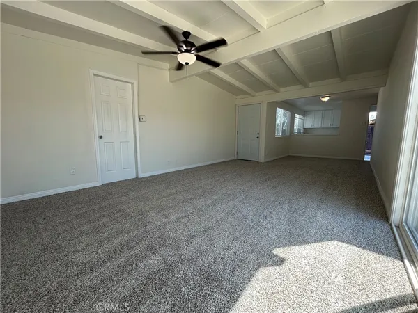 an empty room with a ceiling fan and window